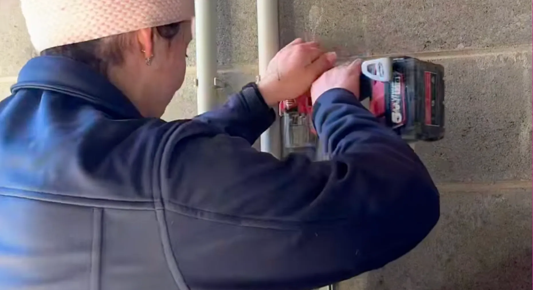 Miranda drilling into a block wall on a commercial job